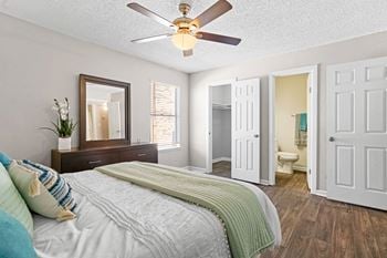 A bedroom with a large bed and a ceiling fan
